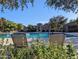 A stunning community pool with lounge chairs and lush landscaping for relaxation at 1814 E Bridgeport Pkwy # 103, Gilbert, AZ 85295