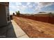 Desert backyard with room for landscaping and a long, red, cinderblock fence at 1820 N Thornton Rd # 917, Casa Grande, AZ 85122