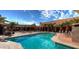 Outdoor swimming pool surrounded by deck chairs and palm trees on a sunny day at 1820 N Thornton Rd # 917, Casa Grande, AZ 85122