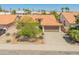 Wide aerial shot of the house nestled in a community with terra cotta rooftops and desert landscaping at 19443 N 36Th St, Phoenix, AZ 85050
