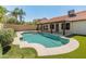 Backyard pool and patio area featuring a pool with surrounding tile, artificial grass, and outdoor lounging at 19443 N 36Th St, Phoenix, AZ 85050