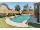 Pool area features a unique shape, lush landscaping, artificial turf, and an overall serene and inviting ambiance at 19443 N 36Th St, Phoenix, AZ 85050