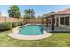 Spacious backyard pool with an artificial turf area, landscaping, and covered patio for lounging at 19443 N 36Th St, Phoenix, AZ 85050