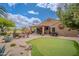 Backyard featuring a covered patio, a putting green, a grill, and various desert plants at 2 W Pasture Canyon Dr, San Tan Valley, AZ 85143
