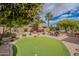 Spacious backyard showcasing a putting green, patio area with furniture, and desert landscaping at 2 W Pasture Canyon Dr, San Tan Valley, AZ 85143