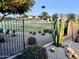Lush backyard with desert landscaping, a black fence, and a view of a green park area at 2 W Pasture Canyon Dr, San Tan Valley, AZ 85143