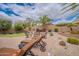 Inviting backyard featuring a fire pit area, desert landscaping, and a lush palm tree at 2 W Pasture Canyon Dr, San Tan Valley, AZ 85143