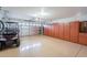 Garage with a red golf cart, an automatic garage door, and a large storage unit on the right side at 2 W Pasture Canyon Dr, San Tan Valley, AZ 85143