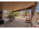 Covered patio area featuring brick flooring, a fire pit, multiple seating areas, and manicured plants at 2 W Pasture Canyon Dr, San Tan Valley, AZ 85143