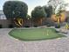 Backyard putting green surrounded by lush landscaping, decorative rocks, and ambient lighting at 2 W Pasture Canyon Dr, San Tan Valley, AZ 85143