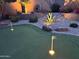 Backyard putting green with flag marker and ambient lighting surrounded by desert landscaping at 2 W Pasture Canyon Dr, San Tan Valley, AZ 85143