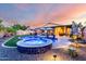 The gorgeous pool and spa are the focal point in this backyard that also includes seating areas, lawn, and covered patio at 2024 E Cherry Hills Pl, Chandler, AZ 85249