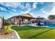Lush backyard featuring a pool, artificial turf, a covered patio, and outdoor seating areas at 2024 E Cherry Hills Pl, Chandler, AZ 85249