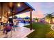 Relaxing backyard with an outdoor kitchen and a sparkling pool with mature palm trees and plenty of patio seating at 2024 E Cherry Hills Pl, Chandler, AZ 85249