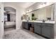 Bathroom featuring double vanity, stylish gray cabinets, decorative mirror lights, and an archway to the primary bedroom at 2024 E Cherry Hills Pl, Chandler, AZ 85249
