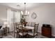 Lovely dining area features a wooden table, six chairs, and stylish lighting fixtures at 2024 E Cherry Hills Pl, Chandler, AZ 85249
