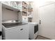 Bright laundry room with modern appliances, including a washer and dryer, and built-in shelving at 2024 E Cherry Hills Pl, Chandler, AZ 85249