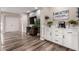 Bright living area with wooden floors, wall-mounted TV, and coffee bar setup with white cabinets at 2024 E Cherry Hills Pl, Chandler, AZ 85249