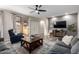 Spacious living room with neutral colors, ceiling fan, tile floors and sliding glass doors to backyard at 2024 E Cherry Hills Pl, Chandler, AZ 85249