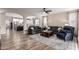 Open-concept living room featuring hardwood floors, comfortable seating and archways to the kitchen at 2024 E Cherry Hills Pl, Chandler, AZ 85249