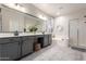Stylish main bathroom with double vanity, a large mirror, soaking tub and glass-enclosed shower at 2024 E Cherry Hills Pl, Chandler, AZ 85249