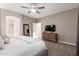 Serene main bedroom boasting plush carpet, ceiling fan, dresser with TV and an en-suite bathroom at 2024 E Cherry Hills Pl, Chandler, AZ 85249