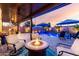 Outdoor covered seating area next to the pool has a fire pit, grill, ceiling fan, and comfortable chairs under the sunset at 2024 E Cherry Hills Pl, Chandler, AZ 85249