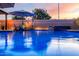 Relaxing backyard oasis with a sparkling blue pool, waterfall feature, and lush landscaping at 2024 E Cherry Hills Pl, Chandler, AZ 85249