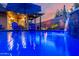 An inviting pool features a rock waterfall, patio, seating, landscaping, lighting, a covered patio, and an outdoor dining area at 2024 E Cherry Hills Pl, Chandler, AZ 85249