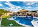 Stunning pool and spa with lounge chairs and umbrellas, complemented by artificial grass and travertine at 2024 E Cherry Hills Pl, Chandler, AZ 85249