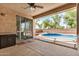 Inviting back patio featuring a sparkling pool, ceiling fan, and access to indoor living spaces at 2112 E Yellowstone Pl Pl, Chandler, AZ 85249