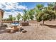 Expansive backyard with desert landscaping, a built-in grill, a table with seating, and a clear blue sky at 2112 E Yellowstone Pl Pl, Chandler, AZ 85249