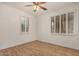 Bright bedroom featuring wood floors, ceiling fan, and windows with white shutters allowing natural light at 2112 E Yellowstone Pl Pl, Chandler, AZ 85249