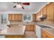 Well-lit kitchen featuring wood cabinetry, granite countertops, an island, and a gas stovetop at 2112 E Yellowstone Pl Pl, Chandler, AZ 85249