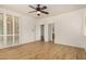 Large bedroom featuring wood-style flooring, white walls, shutters, and access to the en suite bathroom at 2112 E Yellowstone Pl Pl, Chandler, AZ 85249