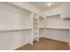 Large walk-in closet featuring multiple shelving units, rods, and neutral carpeting at 2112 E Yellowstone Pl Pl, Chandler, AZ 85249