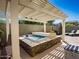 Relaxing backyard oasis with covered hot tub, lounge chairs, and desert landscaping at 21134 W Green St, Buckeye, AZ 85396