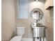 Unique half-bathroom with a stainless steel sink, round mirror, and neutral wall colors at 21134 W Green St, Buckeye, AZ 85396