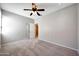 A neutral bedroom featuring plush carpet, a ceiling fan, and an open door to another room at 21134 W Green St, Buckeye, AZ 85396