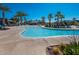Community pool features a zero entry access, lounge seating and mature palm trees at 21134 W Green St, Buckeye, AZ 85396