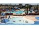 Beautiful Community pool with sunbathers and swimming areas with palm trees and shade umbrellas at 21134 W Green St, Buckeye, AZ 85396