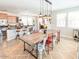 Bright dining area featuring a rustic wooden table, modern lighting, open layout, and stainless steel appliances at 21134 W Green St, Buckeye, AZ 85396