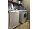 Functional laundry room with front loading washer, dryer, and overhead shelving at 21134 W Green St, Buckeye, AZ 85396