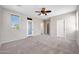 Spacious bedroom with a ceiling fan, carpet flooring, a door to the exterior, and natural light at 21134 W Green St, Buckeye, AZ 85396