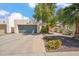 Inviting single-story home featuring a gray garage door and desert landscaping with colorful flowers at 2170 E Alameda Dr, Tempe, AZ 85282