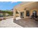 A lovely covered patio with tile flooring overlooks lush landscaping and includes a cozy seating area near the window at 2170 E Alameda Dr, Tempe, AZ 85282