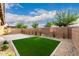 Fully landscaped backyard featuring artificial turf, pavers, gravel, string lights, and brick wall at 21972 N 97Th Gln, Peoria, AZ 85383