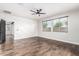 Bright bedroom with wood-look floors, a ceiling fan, and designer wall paneling at 21972 N 97Th Gln, Peoria, AZ 85383