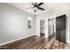 A spacious bedroom with wood-look floors, a walk-in closet and a modern ceiling fan at 21972 N 97Th Gln, Peoria, AZ 85383