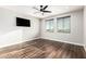 Spacious bedroom with dark wood floors, large windows, and a modern ceiling fan at 21972 N 97Th Gln, Peoria, AZ 85383